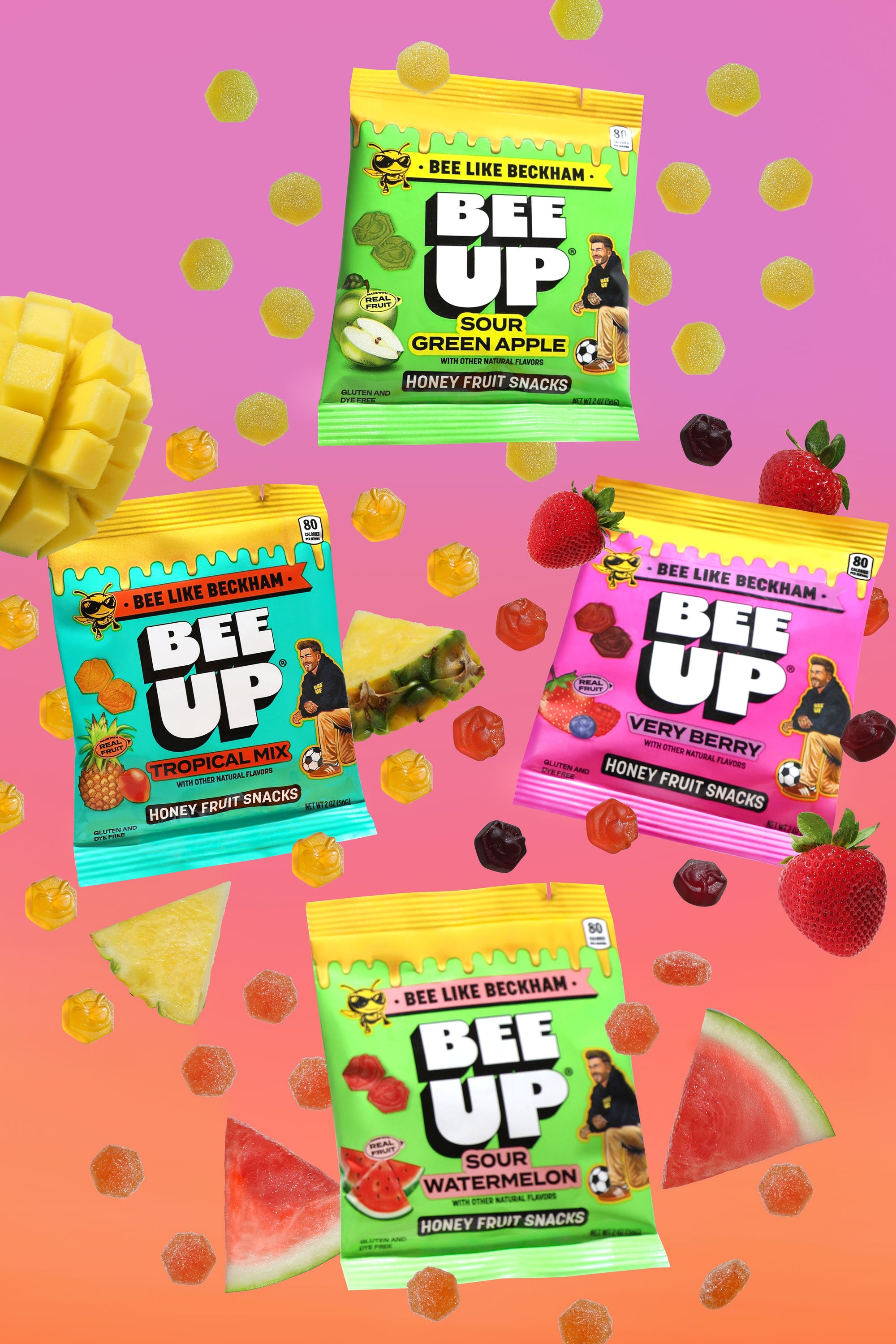 Four colorful packages of Bee Up honey fruit snacks on a gradient background with fruit slices and candies.