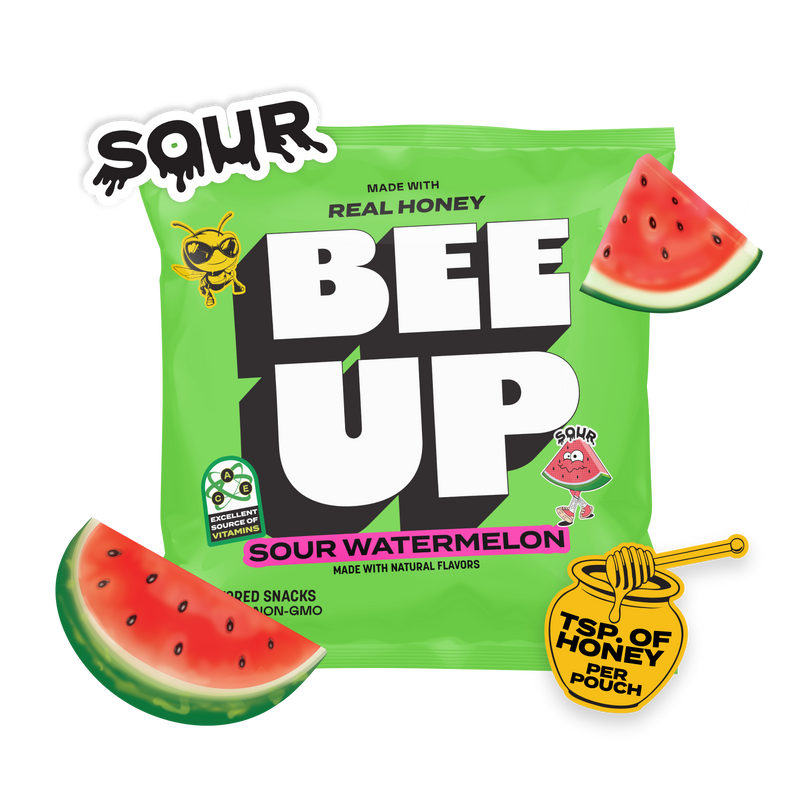 A green pouch of "Sour Watermelon" BEEUP honey fruit snacks surrounded by slices of watermelon, and a honey jar & dipper sticker